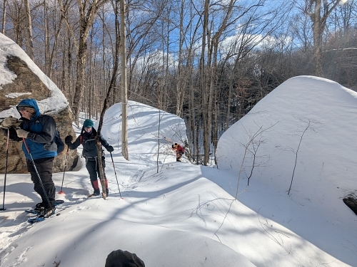 PATC-STS skiers come up through the gap in the rocks